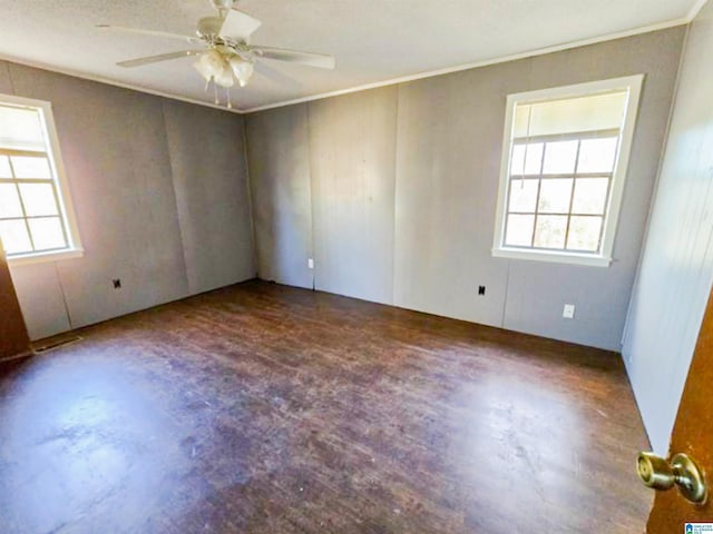 empty room with a healthy amount of sunlight, crown molding, and ceiling fan