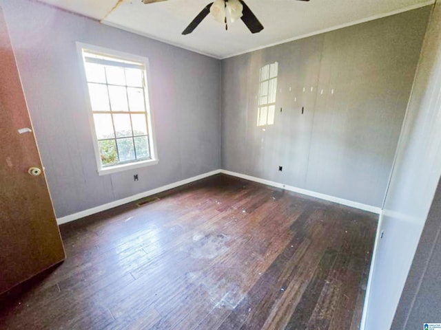 empty room with a ceiling fan, baseboards, visible vents, and hardwood / wood-style floors