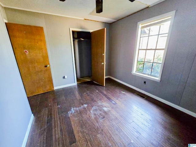 unfurnished bedroom with a ceiling fan, wood-type flooring, visible vents, and baseboards