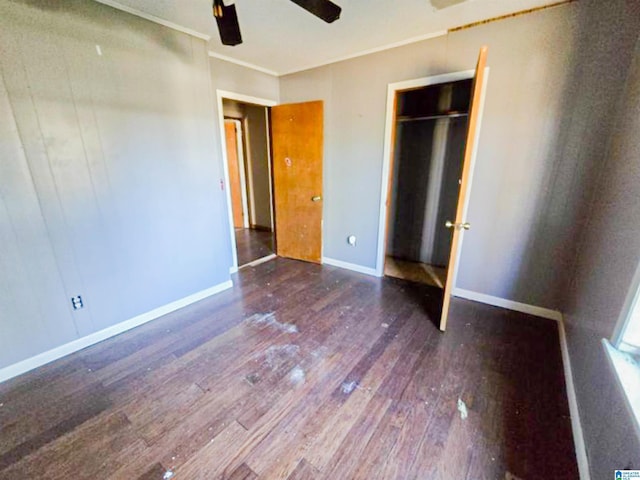 unfurnished bedroom with wood-type flooring, crown molding, baseboards, and ceiling fan