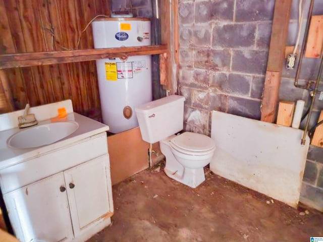 bathroom featuring concrete block wall, gas water heater, unfinished concrete flooring, toilet, and vanity