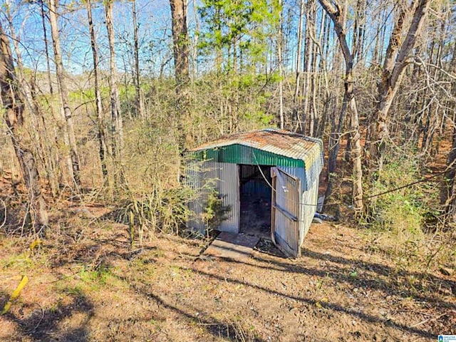 view of shed featuring a view of trees