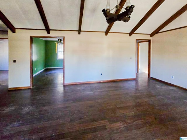 spare room with lofted ceiling with beams, baseboards, and wood finished floors