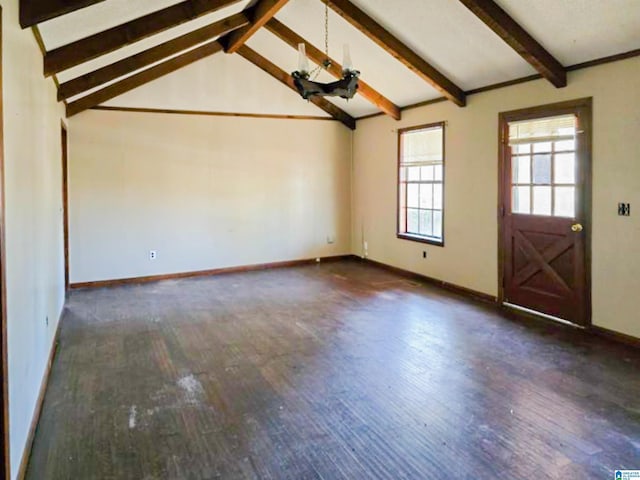 interior space featuring lofted ceiling with beams, baseboards, and wood finished floors