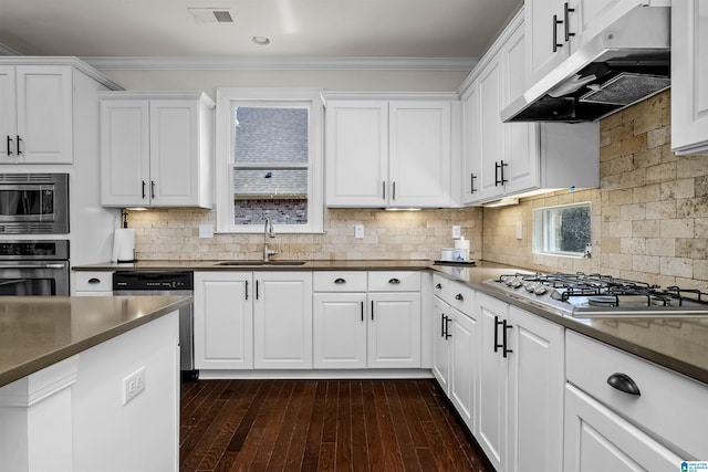 kitchen with visible vents, dark countertops, stainless steel appliances, under cabinet range hood, and a sink