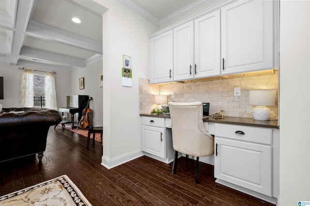 office area featuring baseboards, ornamental molding, dark wood-style floors, built in desk, and beamed ceiling