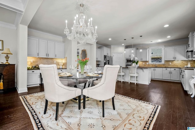 dining space with ornamental molding, dark wood-type flooring, an inviting chandelier, and recessed lighting