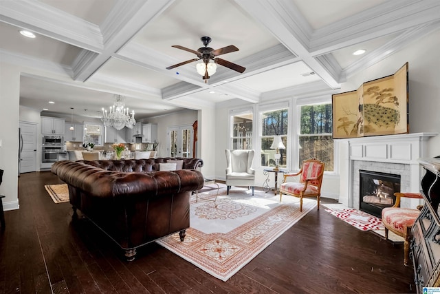 living area featuring beam ceiling, a brick fireplace, dark wood finished floors, and a wealth of natural light