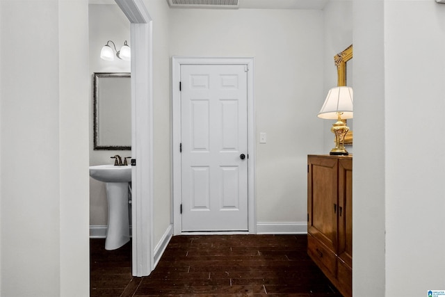 bathroom with hardwood / wood-style flooring, visible vents, baseboards, and a sink