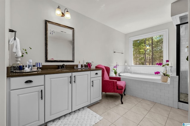 bathroom with a bath, tile patterned flooring, and vanity