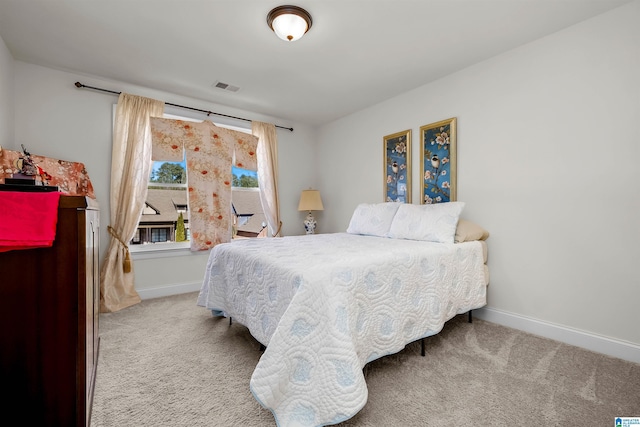 bedroom with carpet floors, visible vents, and baseboards