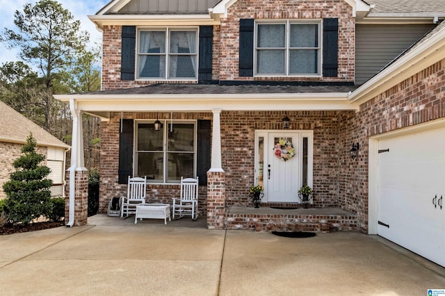 view of front of house with a garage, covered porch, board and batten siding, and brick siding