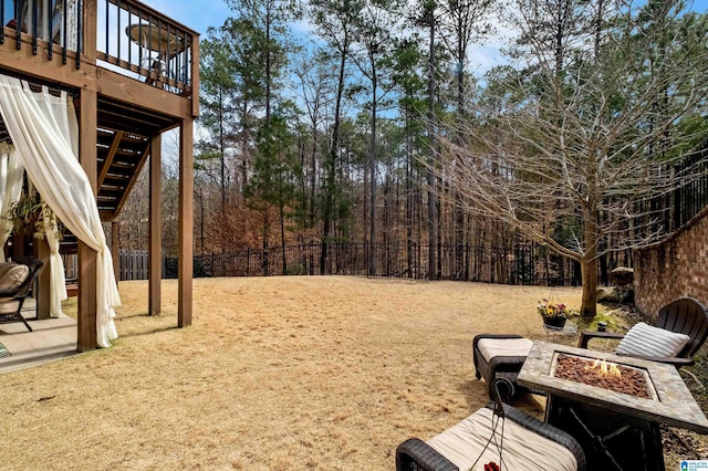 view of yard with stairway, fence, a fire pit, and a deck