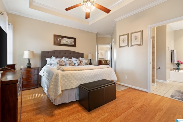 bedroom featuring ornamental molding, a tray ceiling, and baseboards