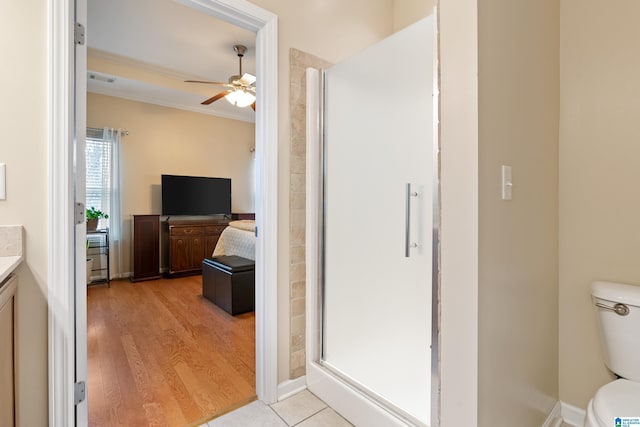 full bathroom featuring toilet, ornamental molding, wood finished floors, vanity, and a shower stall