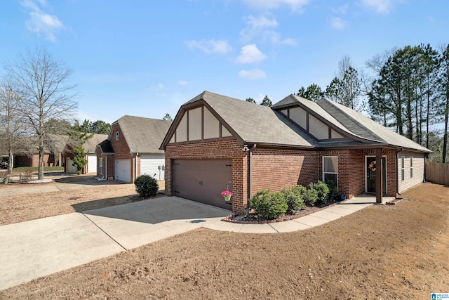 tudor home featuring a garage, brick siding, concrete driveway, roof with shingles, and stucco siding