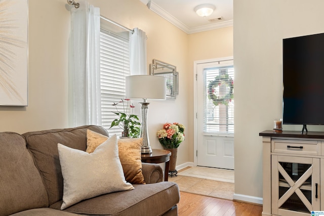 interior space featuring ornamental molding, visible vents, light wood-style floors, and baseboards