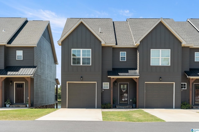 view of front of home featuring board and batten siding, roof with shingles, driveway, and a garage