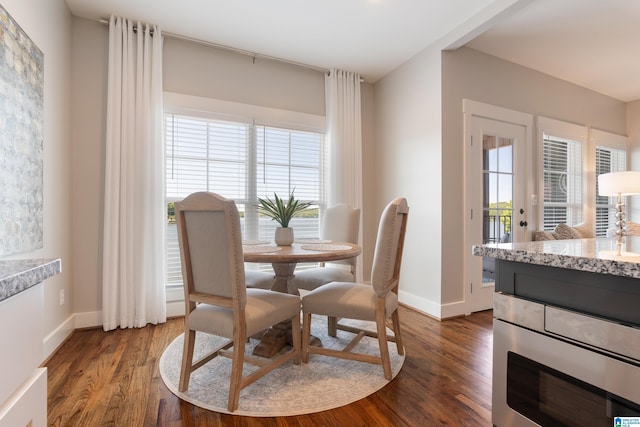 dining area featuring baseboards, dark wood-type flooring, and a wealth of natural light