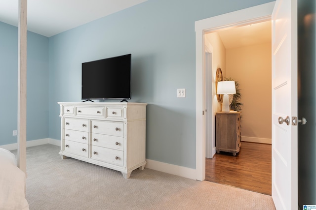 bedroom featuring light colored carpet and baseboards