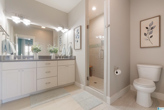 full bath with toilet, a sink, baseboards, double vanity, and a stall shower