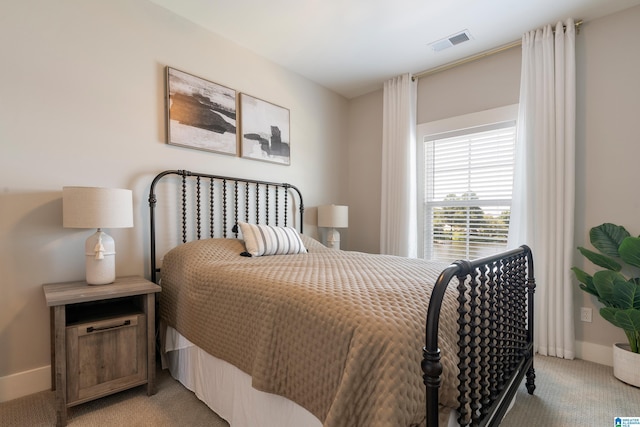bedroom with light colored carpet, visible vents, and baseboards