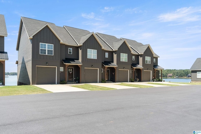 townhome / multi-family property with a garage, board and batten siding, and a water view