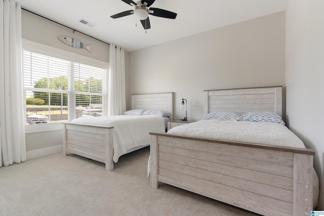 carpeted bedroom with baseboards, visible vents, and a ceiling fan