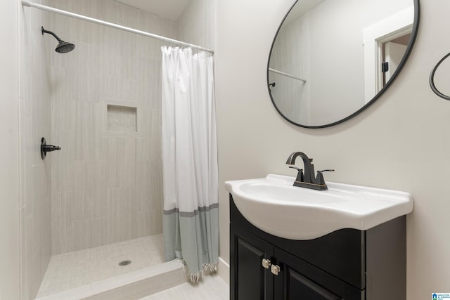 full bath featuring a tile shower and vanity