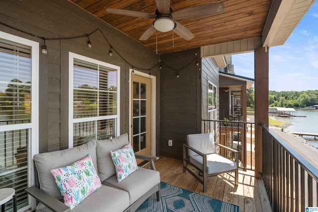 balcony with a water view and a ceiling fan