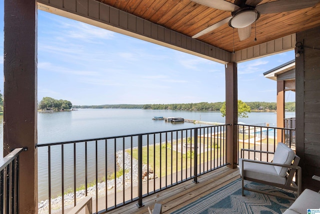 balcony with a water view and a ceiling fan