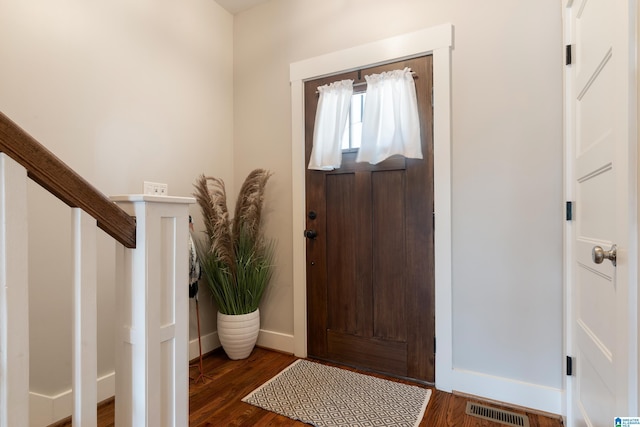 entrance foyer with baseboards, stairs, visible vents, and wood finished floors