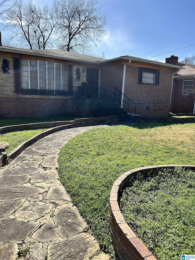 view of front of property featuring a front lawn and brick siding