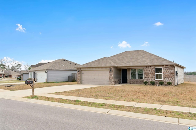 single story home featuring brick siding, a shingled roof, concrete driveway, an attached garage, and a front yard