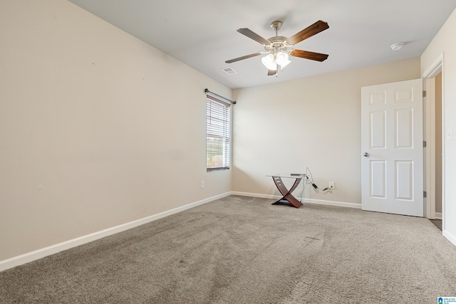 empty room featuring a ceiling fan, carpet, visible vents, and baseboards