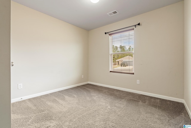 carpeted spare room with visible vents and baseboards