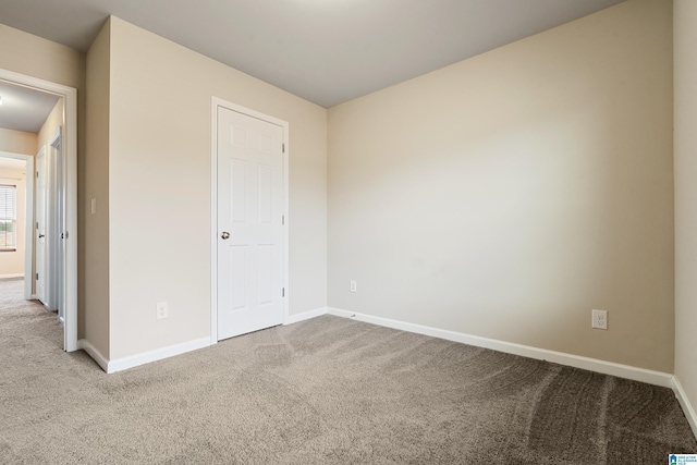 unfurnished bedroom featuring carpet floors and baseboards