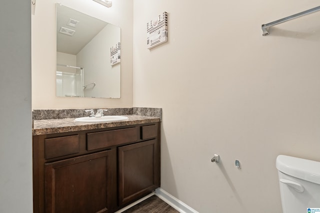 bathroom featuring toilet, baseboards, and vanity