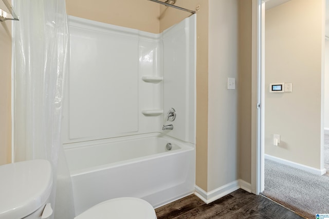 bathroom with shower / tub combo, baseboards, toilet, and wood finished floors