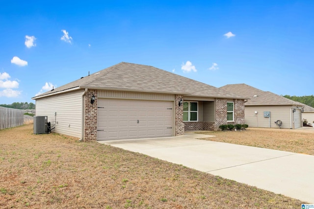 ranch-style home featuring a garage, central AC, brick siding, and a front lawn