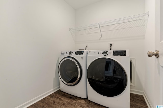 washroom featuring laundry area, baseboards, dark wood-type flooring, and washer and dryer