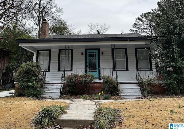 bungalow-style house with a porch and a chimney