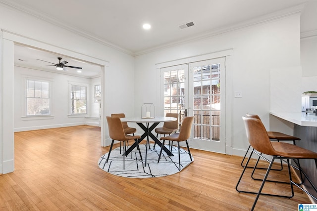 dining area with visible vents, baseboards, ceiling fan, ornamental molding, and light wood-style flooring