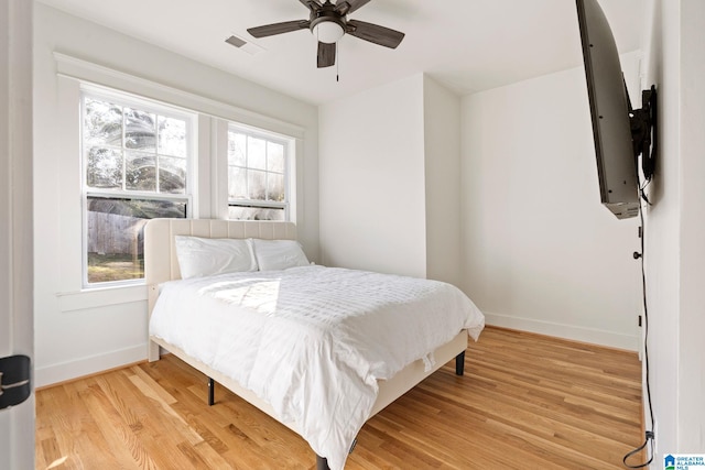 bedroom with visible vents, multiple windows, baseboards, and light wood-style flooring