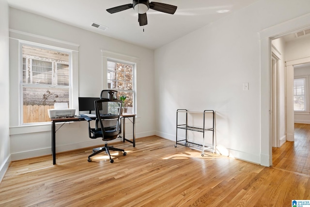 office with visible vents, baseboards, ceiling fan, and wood finished floors