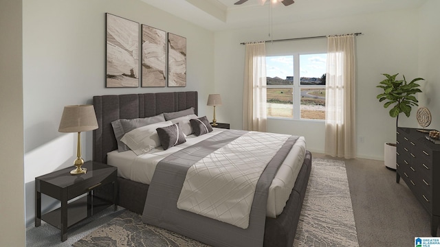 bedroom featuring ceiling fan, a tray ceiling, and carpet flooring