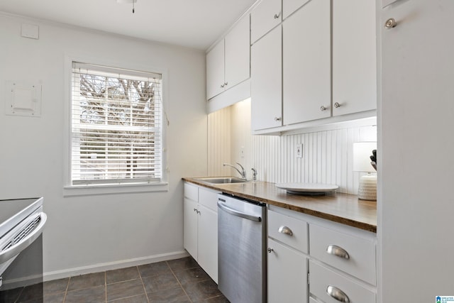 kitchen with butcher block countertops, white cabinets, appliances with stainless steel finishes, and a sink