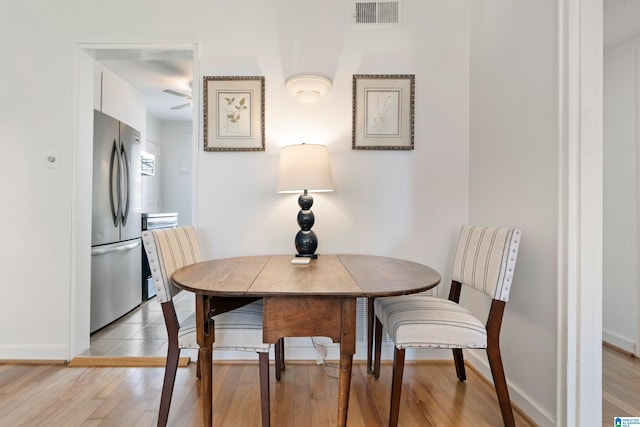 dining space with visible vents, baseboards, and light wood-style flooring