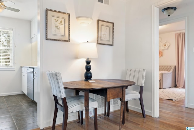 dining area with visible vents, baseboards, a ceiling fan, and wood finished floors