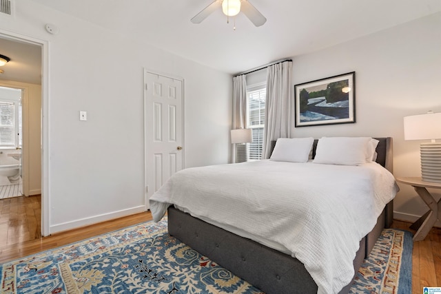 bedroom with a ceiling fan, visible vents, wood finished floors, and baseboards